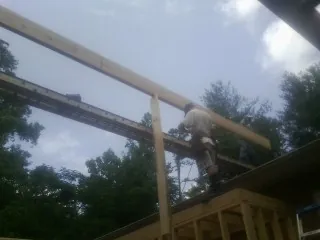 Carpenter setting a ridge beam over a new addition frame — Ice Dam Removal by Roofing Brothers in Callicoon