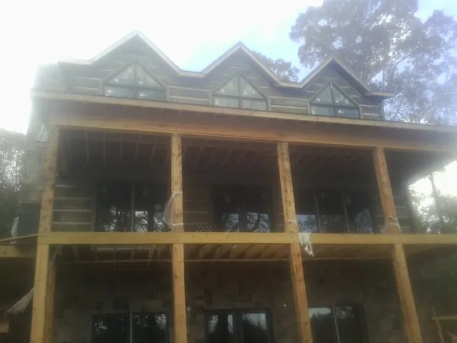 Dormers and porch framing on a large log home under construction — Roof Coating work by our crew in Callicoon