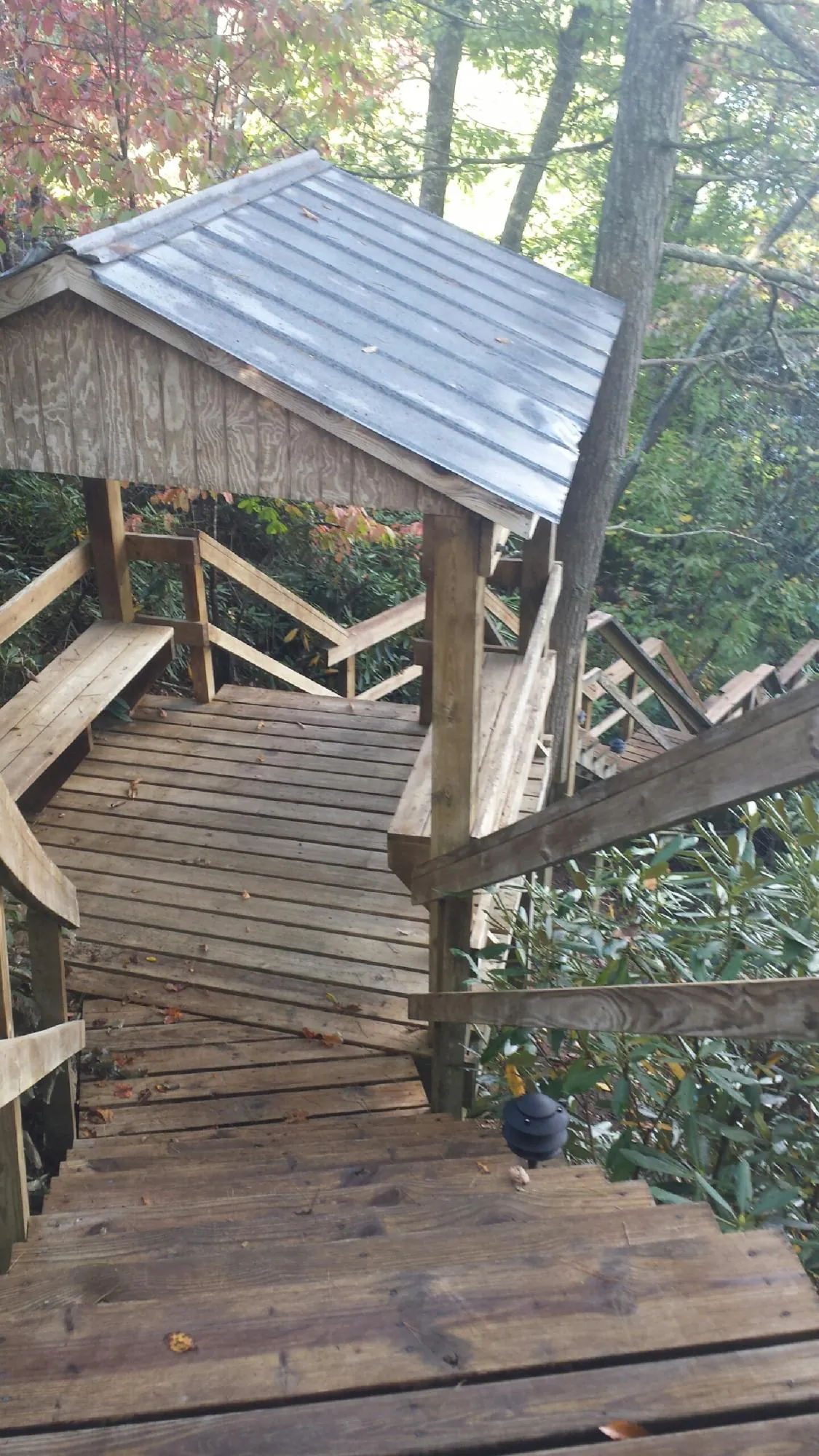 Metal roofed shelter over wooden steps on a wooded walkway — Skylight Repair & Installation work by our crew in Callicoon